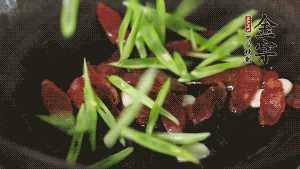 先后下香腸片、四季豆絲均勻翻炒，加適量清水燜煮一下。