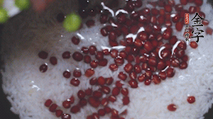 將炒好的食材和大米、紅豆一起放進(jìn)電飯鍋煮。