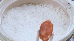 煮開后轉(zhuǎn)小火，當米飯出現(xiàn)小孔時，鋪上金字麻辣香腸。