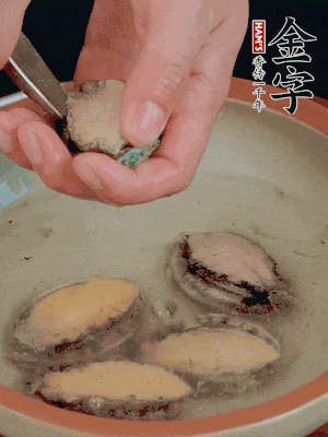鮑魚加鹽、清水浸泡，用勺子挖出鮑魚肉。