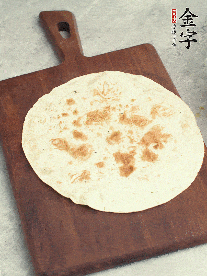 食材依次鋪在卷餅皮上，卷起來。