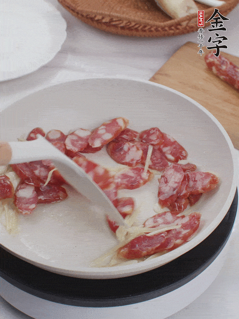 油溫3成熱時(shí)，下姜絲、蒜片、香腸炒出油脂。