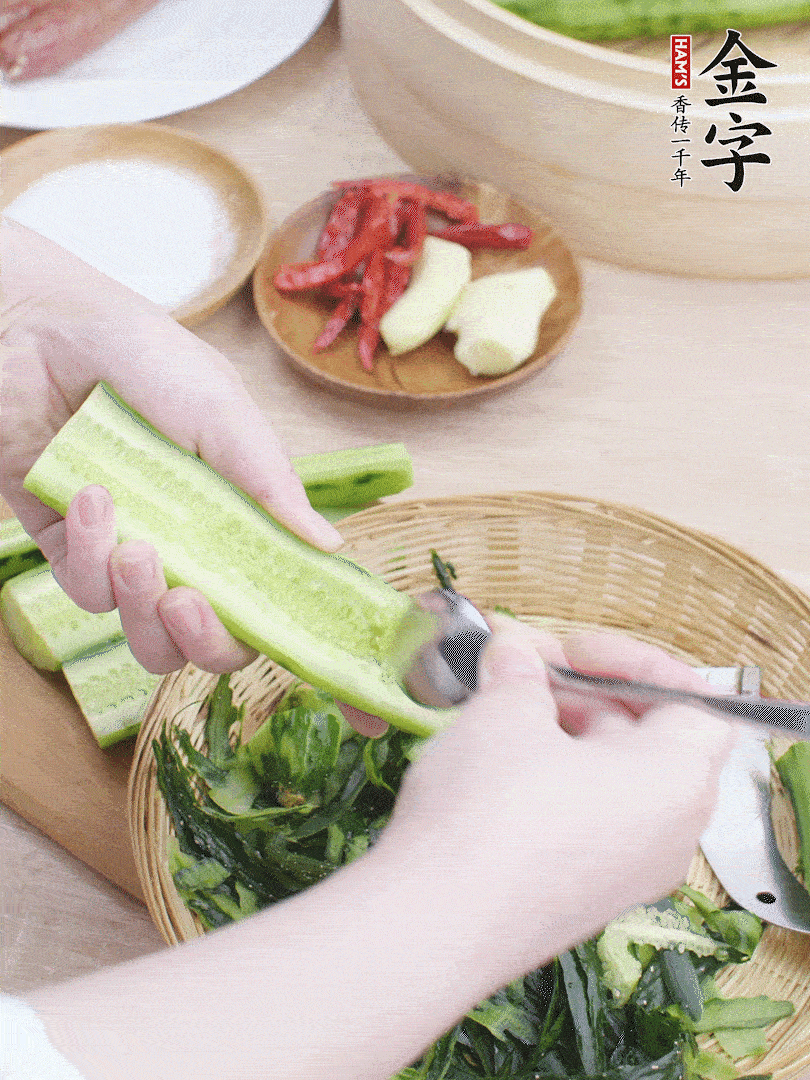 黃瓜削皮，對半切開，勺子挖去內瓤，斜刀切片。青蒜斜刀切段。