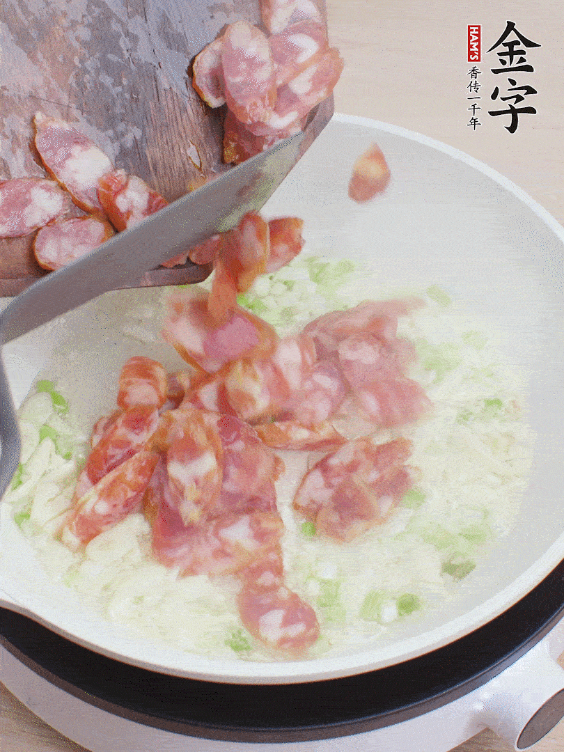 油5成熱，蒜末、蔥白爆香，下香腸炒出香味。