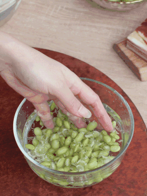 青豆剝殼，搓去外衣。