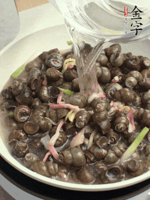 倒處理干凈的螺螄翻炒，加3勺料酒。加清水蓋過螺螄，中火蓋蓋煮5分鐘。