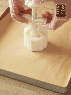 取一個面團(tuán)，捏扁，中間厚，四周薄。虎口往上推，直到收口，把餅胚放入模具里，壓2-3下