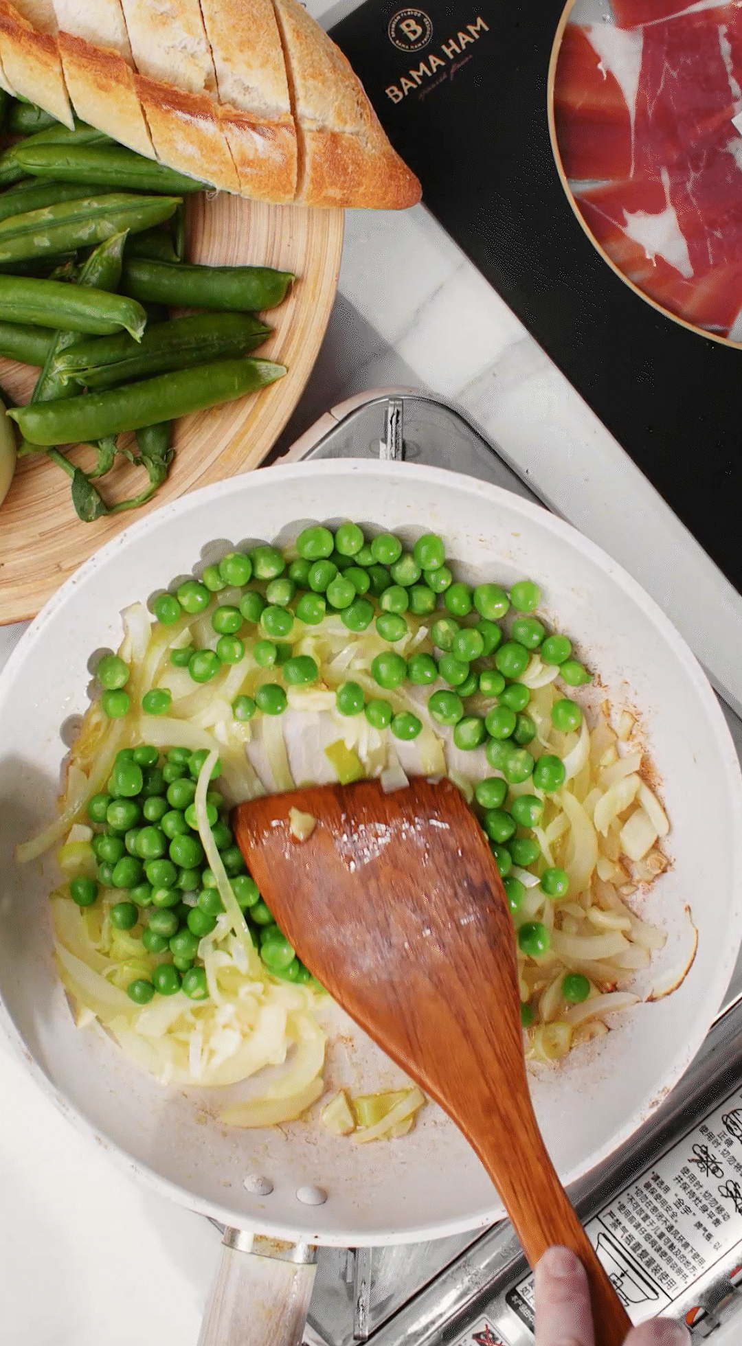 鍋中放入黃油融化，加入洋蔥絲、大蔥蔥白絲、蒜末翻炒變軟出香味。加入剛剛汆燙冰鎮(zhèn)后的豌豆，取出一點(diǎn)點(diǎn)待會(huì)擺盤裝飾用。加一點(diǎn)鹽 (和黑胡椒) 調(diào)味。