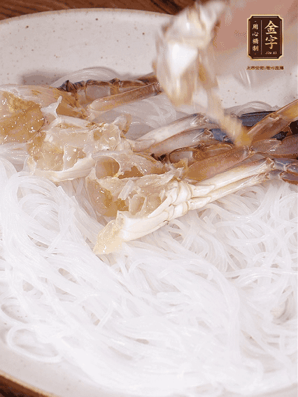 盤(pán)底墊上粉絲，擺上梭子蟹、火腿片，撒姜粒，淋上蒸魚(yú)豉油、花雕酒調(diào)味腌制15分鐘